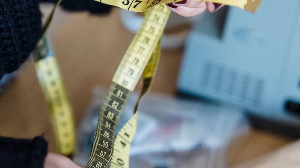 双手把一条软尺抻开、对着刻度看 —— 人到你所在的城市,量体这一步才落得下来